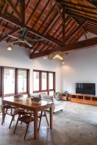 a large living room with a table and a tv at White Coral Villa - Private Villa & Pool in Gili Air +4 photos