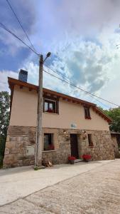 a stone house with a street light in front of it at Vivienda de Uso Turístico Los Castaños in San Román de Sanabria