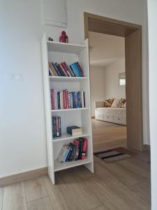 a book shelf filled with books in a living room at Apartman Ante Škoda Pivica in Povljana