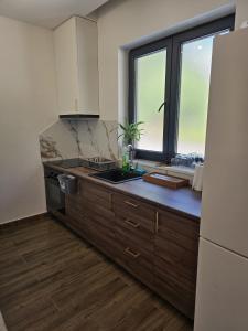 a kitchen with a sink and a large window at Apartments Villa Joja in Međugorje +7 photos