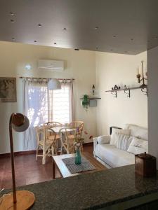 a living room with a couch and a table and chairs at Buen Descanso I in San Pedro +4 photos