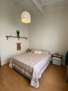 a white bedroom with a bed and a lamp at Buen Descanso I in San Pedro