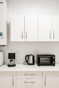 a kitchen counter with a microwave and a coffee maker at Alojamiento Baeza - El Limonero A in Baeza