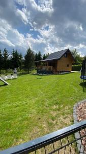 a house with a yard with chairs and a building at Domek letniskowy Zacisze 2 in Urowo
