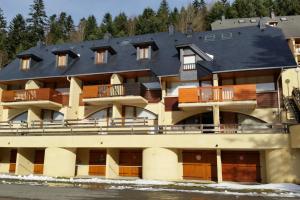 a large apartment building with a large roof at Studio payolle face lac et du Pic du Midi in Barrancoueu