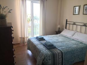 ein Schlafzimmer mit einem Bett und einem großen Fenster in der Unterkunft Casa Ensenada - 1a linea de playa in Rota