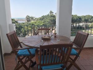 ein Holztisch und Stühle auf einem Balkon in der Unterkunft Casa Ensenada - 1a linea de playa in Rota