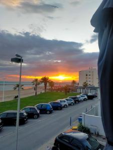 Una fila de autos estacionados en un estacionamiento cerca de la playa. en Bord de mer, en Le Grau-du-Roi