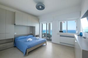 a bedroom with a bed and a kitchen with the ocean at Luxury Penthouses Romeo e Giulietta by GG Apartments in Gallipoli