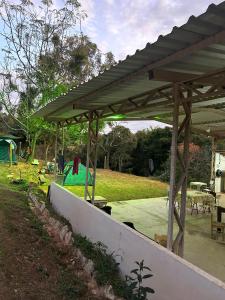 un padiglione in legno in un parco con parco giochi di Camping Shangrilá São Thomé a São Thomé das Letras