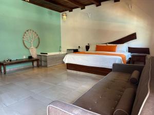 BalcheilClub Cenotes Tulum的带床和沙发的卧室