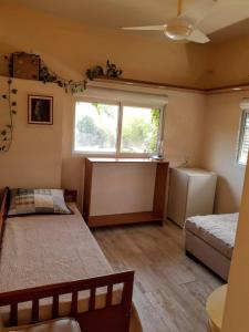 a bedroom with two beds and a window and a refrigerator at Apartamento Verde in Avaré +8 photos