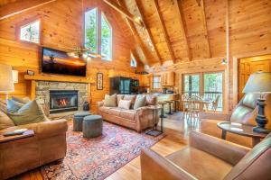 een woonkamer met een open haard in een blokhut bij Roudy’s Roost By Avada Properties in Pigeon Forge