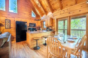 een eetkamer en keuken in een hut met een tafel en stoelen bij Roudy’s Roost By Avada Properties in Pigeon Forge