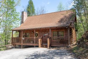 een blokhut met een grote veranda en een terras bij Roudy’s Roost By Avada Properties in Pigeon Forge
