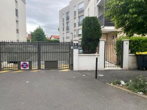 a gate in front of a house with a building at Lit 2 en 1ère Classe-Orly-T7-RER C&D in Athis-Mons