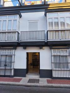 a white building with a door and a balcony at Casa San Juan 55 - Centro Sanlúcar in Sanlúcar de Barrameda