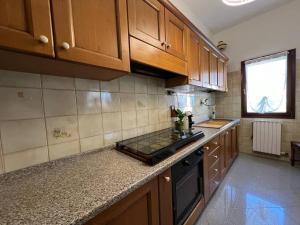 a kitchen with wooden cabinets and a counter top at Ca'Mia - Rooms in Porto Tolle +16 photos