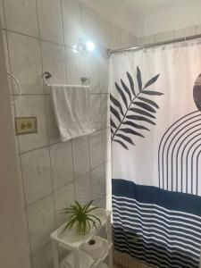 a bathroom with a shower curtain with a plant at Golden Nest in Port Antonio