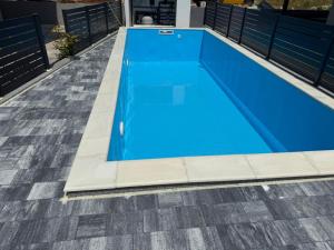a blue swimming pool on top of a house at Apartman sa pogledom na more- Petra in Šilo