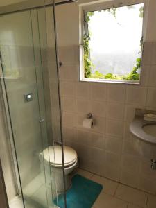 a bathroom with a toilet and a glass shower at Apartamento Verde in Avaré