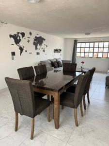 a dining table and chairs in a living room at Suites Incoreli in Pachuca de Soto +13 photos