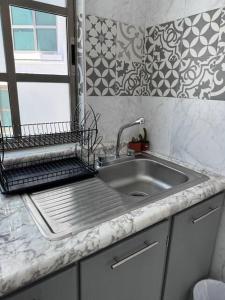 a kitchen counter with a sink and a window at Suites Incoreli in Pachuca de Soto
