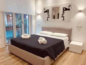 カリアリにあるABBA ROOMSのベッドとタオル2枚のある寝室