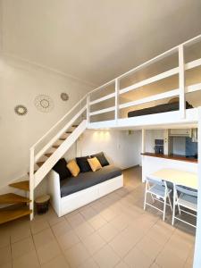 a living room with a couch under a loft bed at Studio front de mer Valras-Plage 2-4 personnes in Valras-Plage