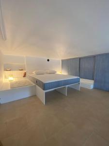 a bedroom with a white bed and a blue wall at Studio front de mer Valras-Plage 2-4 personnes in Valras-Plage