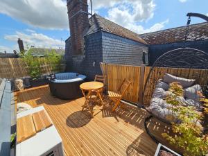 a deck with a hot tub and a table and chairs at L instant Love, passion pure in Verneuil d’Avre et d’Iton +12 photos