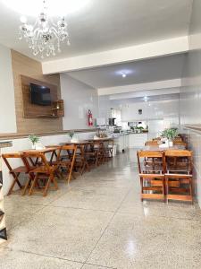 a dining room with wooden tables and a kitchen at Hotel El Shaday in Nazário