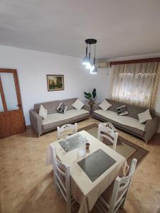 una sala de estar con una mesa y un sofá en Vangert Apartment, en Berat