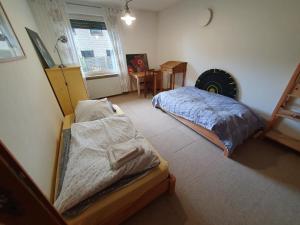 a bedroom with two beds and a table in it at Gemütliches, einfaches Gästezimmer in Oldenburg