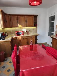 a kitchen with a table with a red table cloth on it at Maison Fatonnette in Vendôme