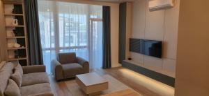 a living room with a tv and a couch and a chair at concept 9 in Târgu-Mureş