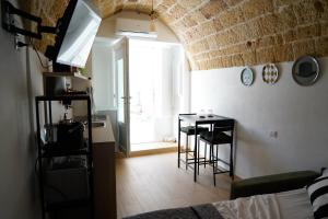 a room with a bed and a table and a window at Sott'o Cambanil in Gioia del Colle