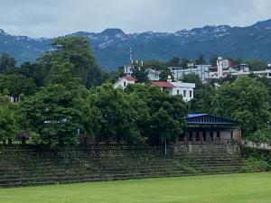 a building in a field with a city in the background at Mount n Mood in Dehradun