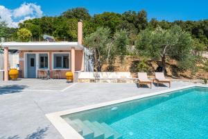 a villa with a swimming pool and a house at Alex bar apartments in Sarakiniko
