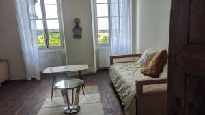 a bedroom with a bed and a stool and windows at Maison Nathis in Saint-Sulpice-de-Roumagnac +79 photos