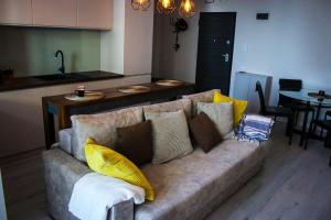 un divano con dei cuscini in un soggiorno di Sea Shine Apartament, frontal sea view a Mamaia Nord - Năvodari Altre 4 foto