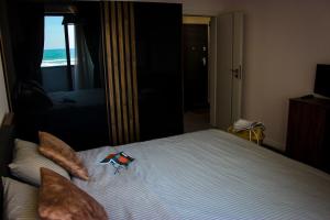 un letto con cuscini e un giocattolo sopra di Sea Shine Apartament, frontal sea view a Mamaia Nord - Năvodari
