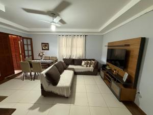 a living room with a couch and a tv at Sana - Chácara Canto do Tiê - 15 hospedes in Casimiro de Abreu