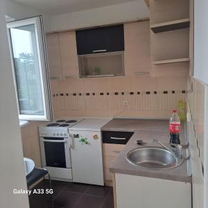 a small kitchen with a sink and a stove at Apartman Kragujevac in Kragujevac