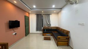 a living room with a couch and a tv at beehive Villa in Padinjarathara