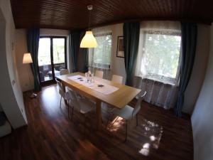 a dining room with a wooden table and chairs at Haus im Park in Sankt Kanzian