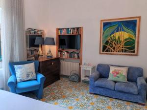 a bedroom with a bed and two chairs and a tv at Room with a view in Salerno