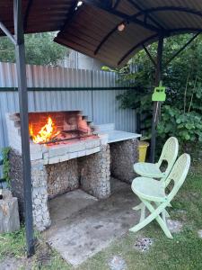 a picnic table and two chairs and a fireplace at Чотири стихії in Mizhhirʼʼya