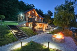 a house with a fire pit in front of it at Kuća za odmor Šokot in Gornja Rijeka