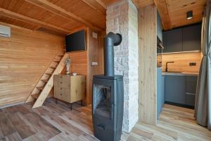 a wood stove in a room with a staircase at Kuća za odmor Šokot in Gornja Rijeka
